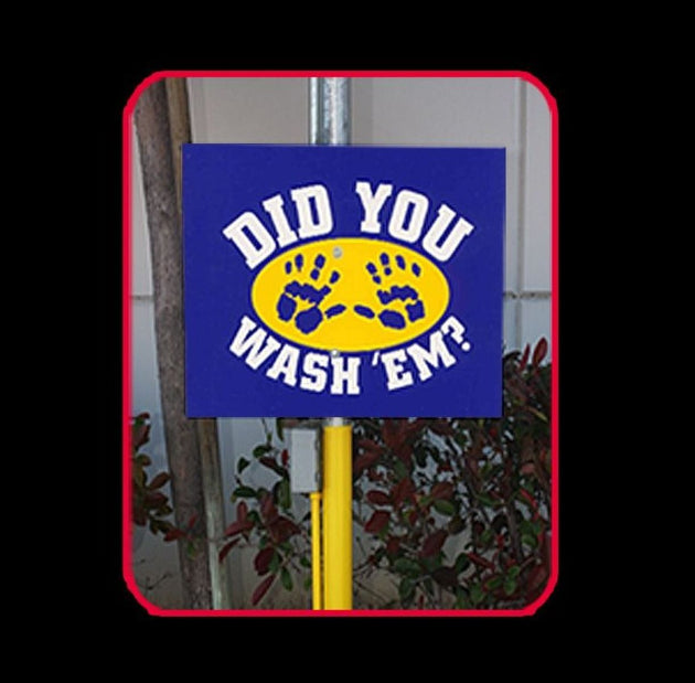 Blue sign with yellow circle and paw prints on a pole against a tiled wall background