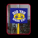 Blue sign with yellow circle and paw prints on a pole against a tiled wall background