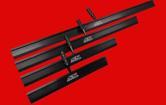 Set of black metal skis with branding on a red background
