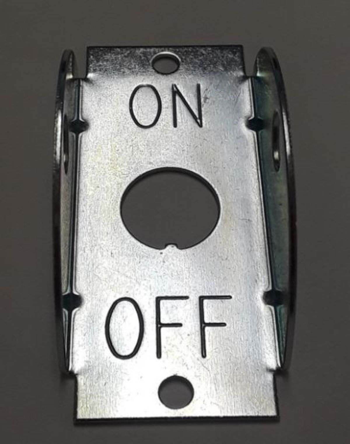 Metal toggle switch with 'ON' and 'OFF' labels on a dark background