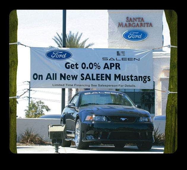Ford dealership with a Saleen Mustang and promotional banner.