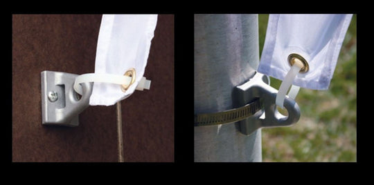 Metal clip holding white fabric against a brown background, with a close-up of the clip on a metal pole.