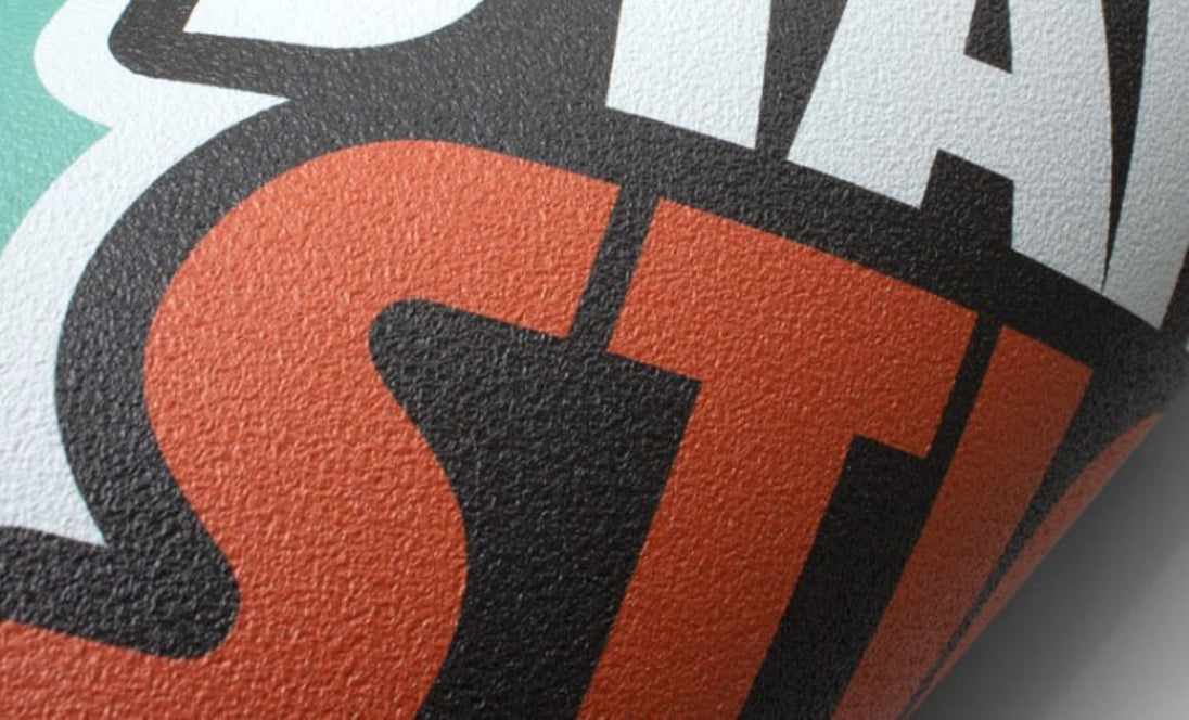 Close-up of a textured surface with 'STAY' text in orange, black, and white.