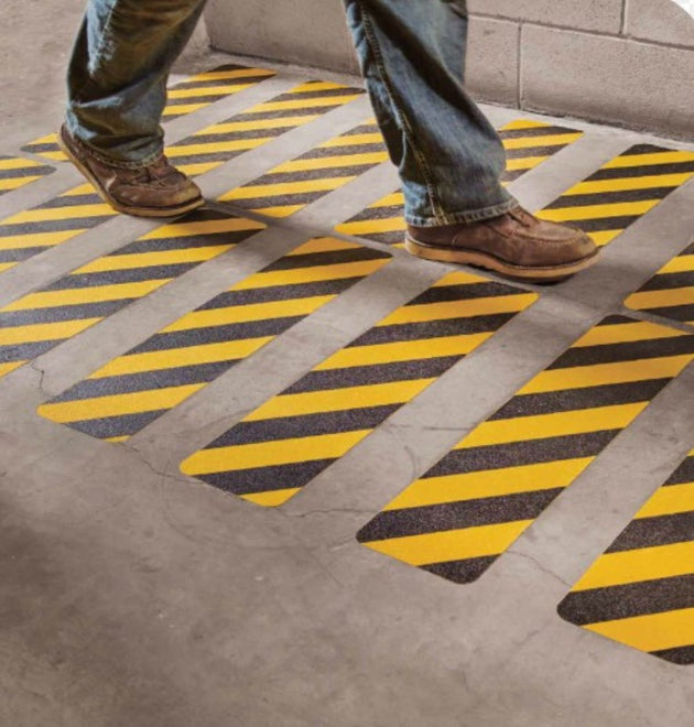 Person walking on a floor with yellow and black striped pattern