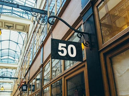 Building facade with a sign displaying the number 50 in an indoor setting with glass ceiling