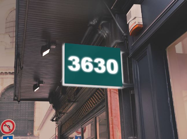 Street sign with the number 3630 on a building facade.