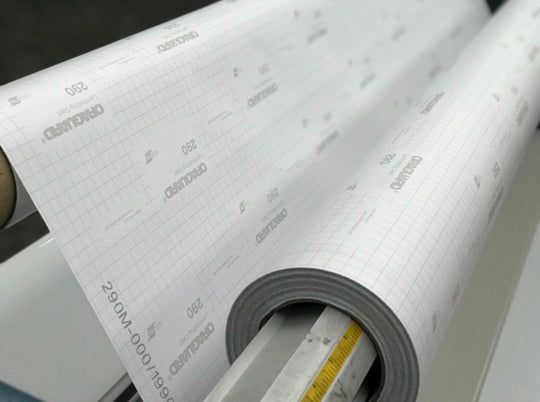 ORAGUARD 290 premium cast overlaminate loaded on a laminator showing the branded release liner