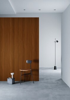 Modern interior with a wooden panel wall, chair, and floor lamp.