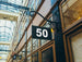 Building facade with a sign displaying the number 50 in an indoor setting with glass ceiling.
