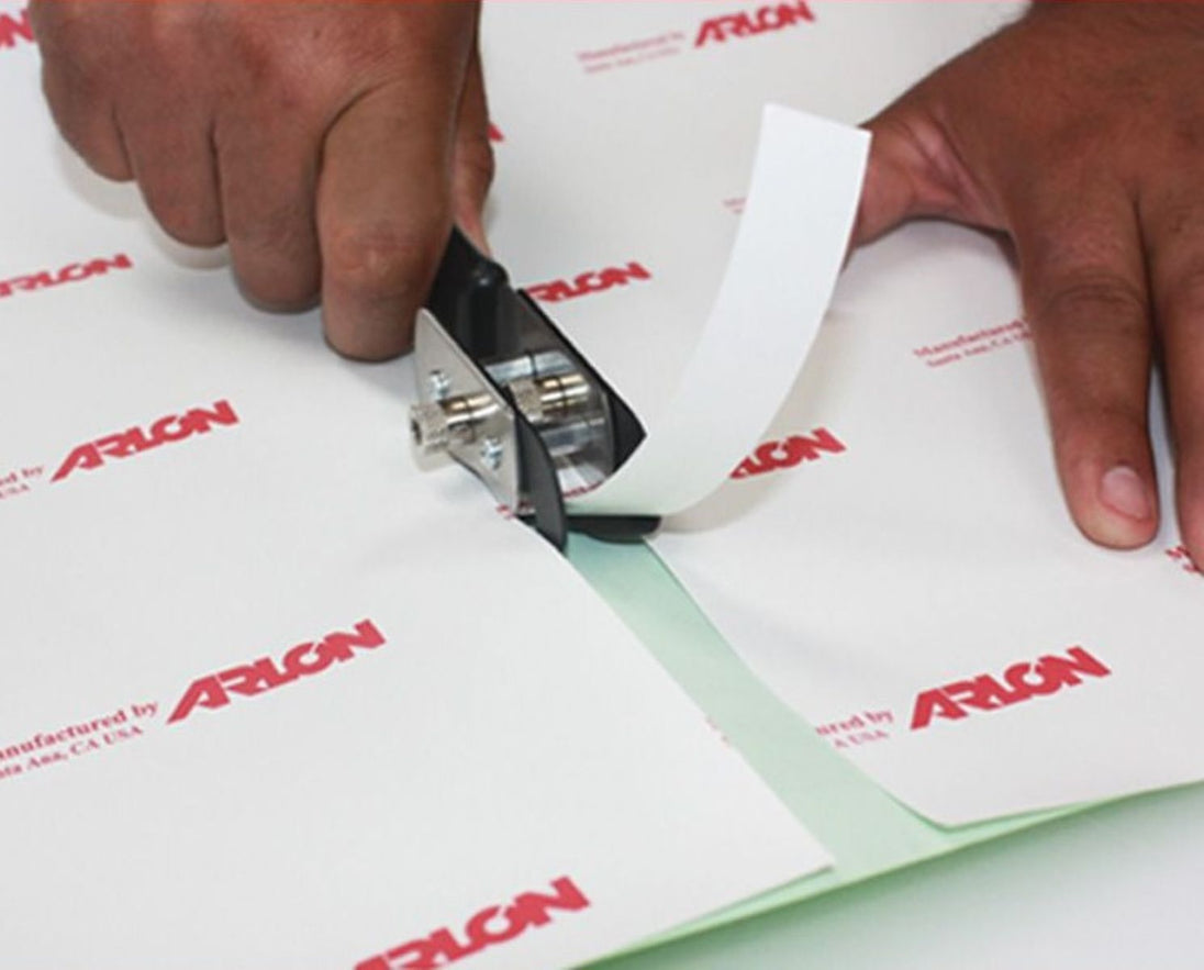 Person using a paper cutter on Arlon branded paper
