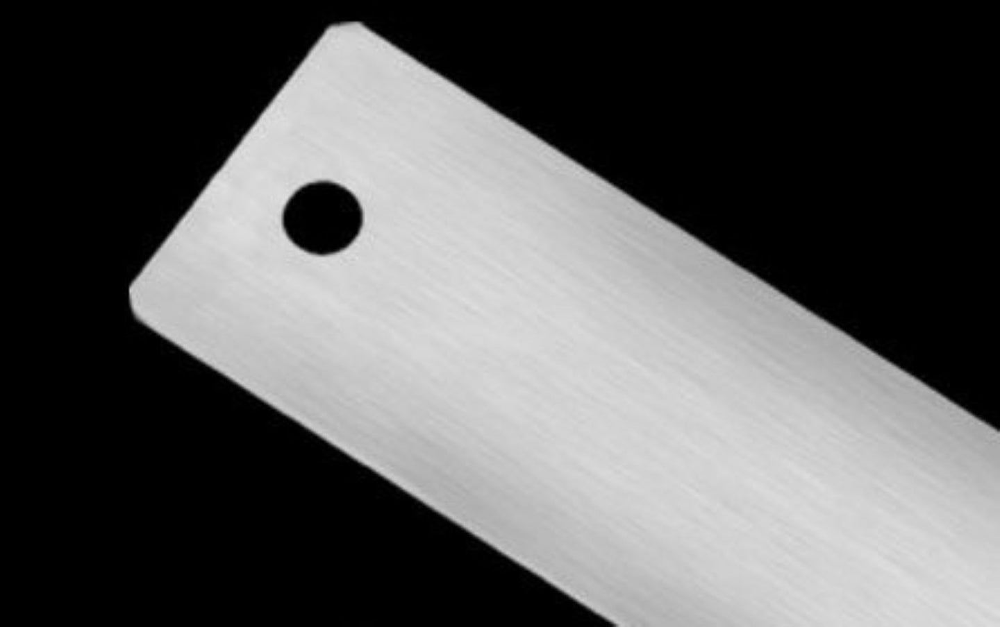 Close-up of a metallic object with a central hole on a black background