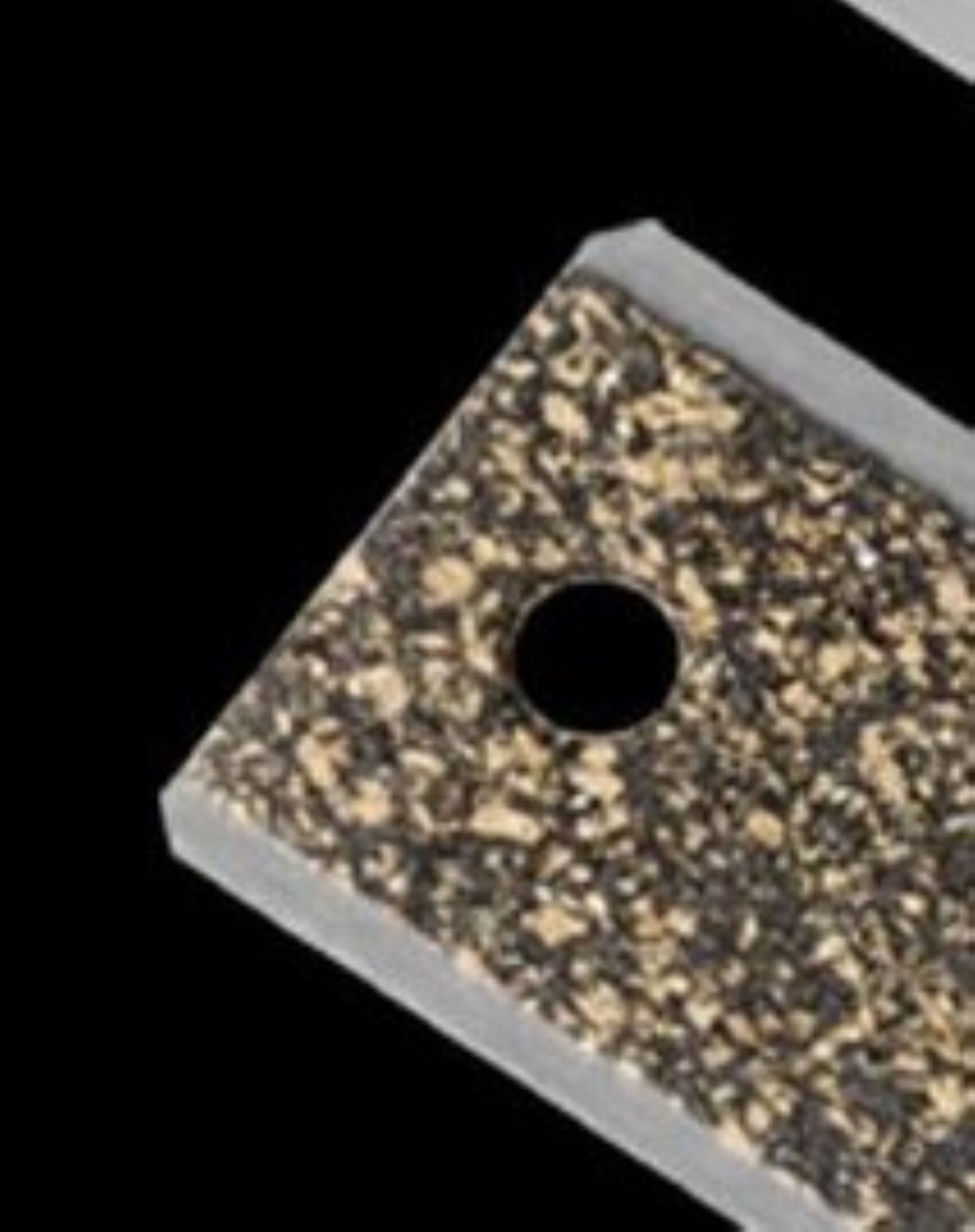 Square rubber mat with a central hole on a black background