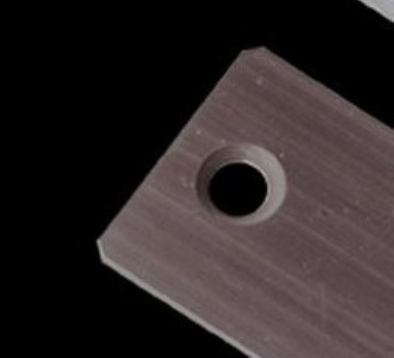 Metallic square with a circular hole on a black background